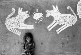 A young girl in front of mandana paintings, Rajasthan